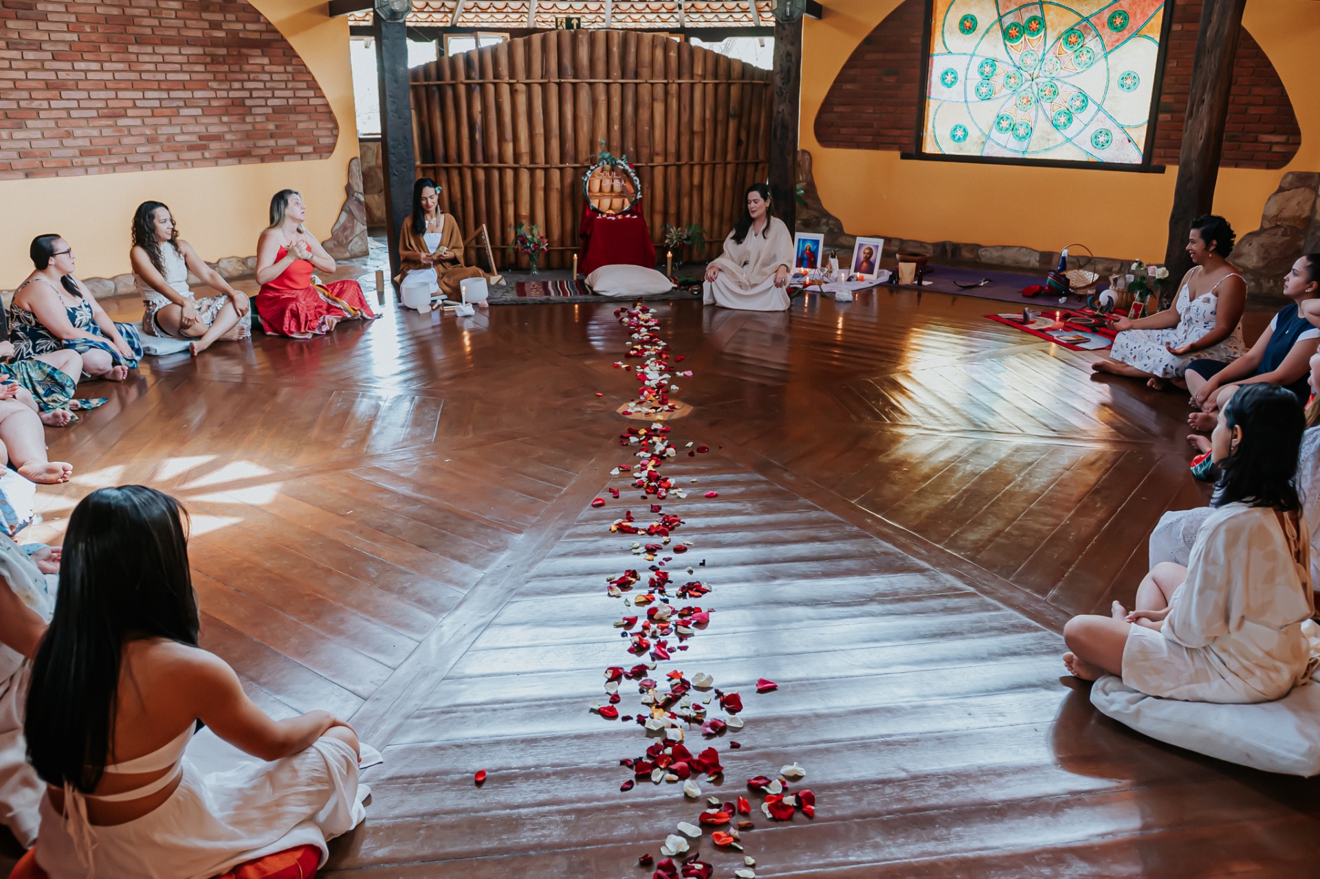 Círculo de mulheres em cerimônia com pétalas de rosas